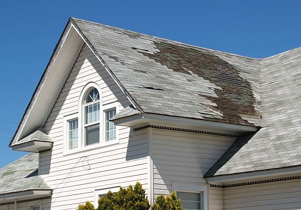 Residential roof with missing and damaged shingles
